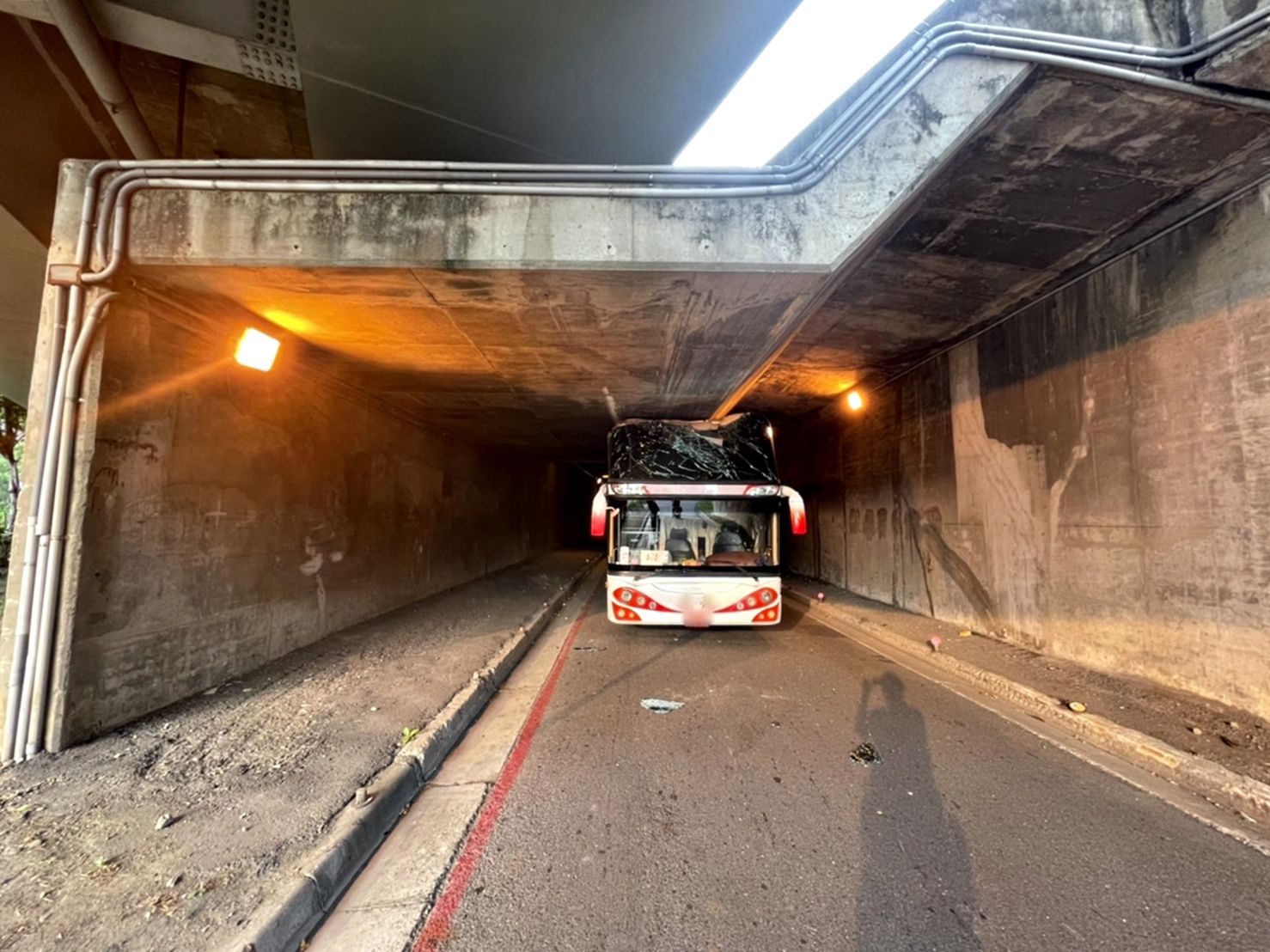 ▲▼遊覽車闖機車道卡涵洞…擋風玻璃全碎 車上都沒人。(圖/讀者提供)