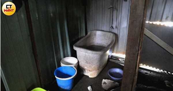 他們用物品簡單分割生活區域,擺上幾個水桶盛接雨水,就是一個簡易的盥洗間。(圖/周志龍攝)