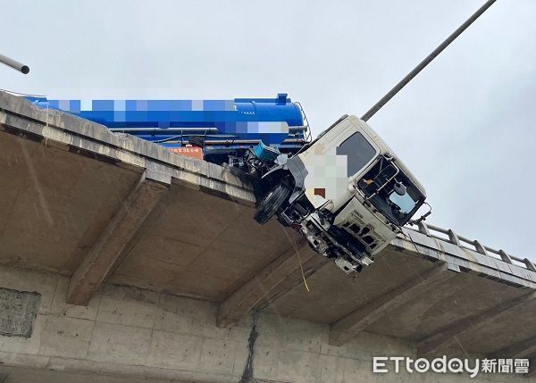 ▲聯結車衝破台61高架橋護欄，車頭懸吊於橋上。（圖／桃園市消防局提供）