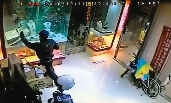歹徒衝進銀樓,掄起鐵鎚敲破展示櫃,搶了金飾就跑。(東森新聞提供)