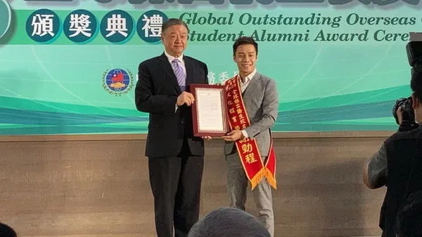 圖一:馬來西亞電台主播、世新大學校友謝勁程(右)獲全球傑出僑生校友表揚,由僑委會副委員長呂元榮(左)授獎。(圖/世新大學提供)