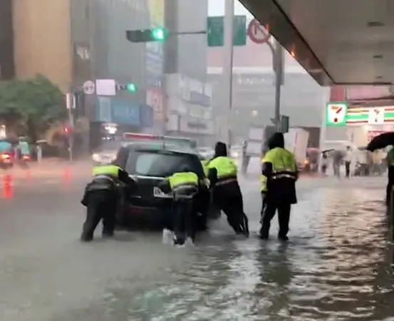 ▲▼▲北市警中正一分局外淹水,警員合力將警車推往高處再行駛離。(圖/民眾提供)