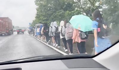 國道驚見「學生排隊」淋雨走路　30多人揹書包沿路肩北上