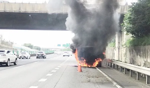 ▲國道2號西向八德段下午3時許發生行駛中砂石車左後輪突然竄出大火。(圖/桃園市消防局提供)