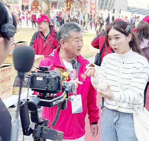 ▲景福宮主委簡征潭與韓國網紅Judy講解鑽轎底祈福之用意。(圖/景福宮提供)