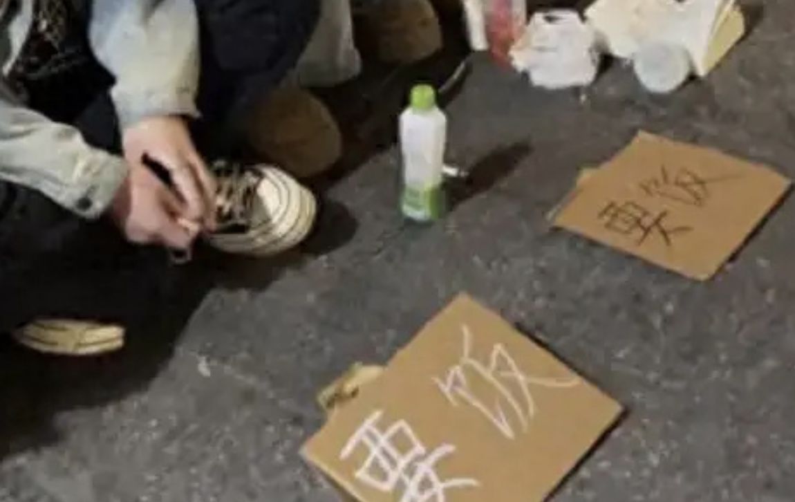 ▲雲南大理街頭出現年輕人「舉牌要飯」的奇怪現象。(圖/翻攝微博)