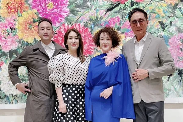 ▲韓湘琴一襲寶藍套裝(中)開畫展,全家總動員。右二:唐威。左二:唐志中。 左五:唐可珊。(圖/韓湘琴提供)