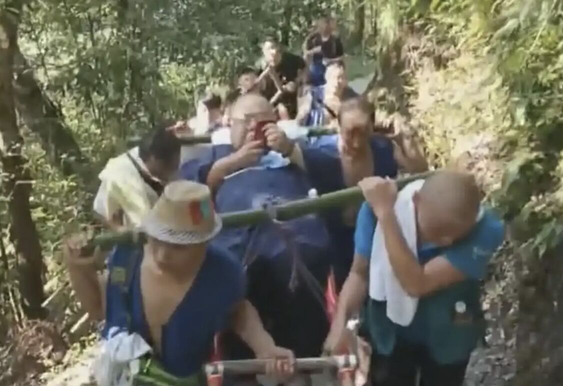 ▲130公斤男子雇轎伕爬峨眉山,轎夫們動用9人輪流扛。(圖/翻攝極目新聞)