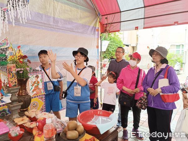 ▲安平靈濟殿「孤棚祭」活動熱鬧登場,國中生擔任解說員,親子共同體驗綁篙餞,200隻豬仔撲滿秒殺一空。(圖/記者林東良翻攝,下同)