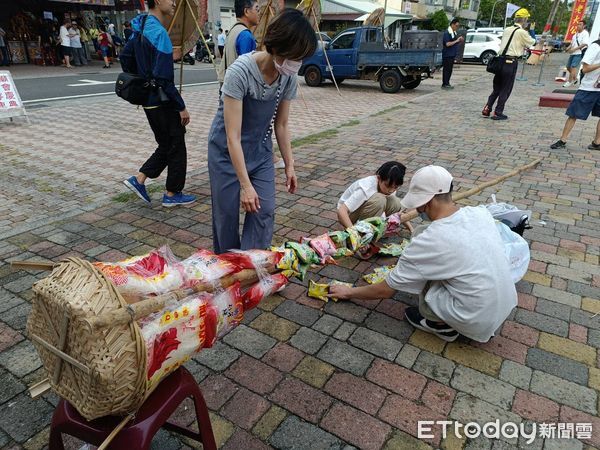 ▲安平靈濟殿「孤棚祭」活動熱鬧登場,國中生擔任解說員,親子共同體驗綁篙餞,200隻豬仔撲滿秒殺一空。(圖/記者林東良翻攝,下同)