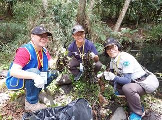 ▲左起宅配通總經理徐慶懿、雪霸處處長林文和及祕書張杏枝合作共同移除外來種植物「漂浮天胡荽」。(圖/宅配通提供)
