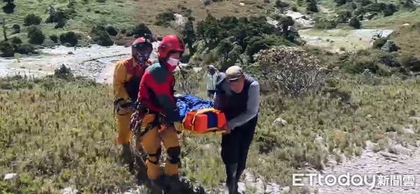 ▲黑鷹直升機於南湖山屋前方空地落地,由特搜隊員使用擔架將男子搬運上機。(圖/記者王兆麟翻攝,下同)