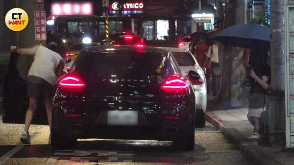 范姜將愛女安置在後座時,黑帽女貼心幫忙撐傘,避免父女倆被雨淋。(圖/本刊攝影組)