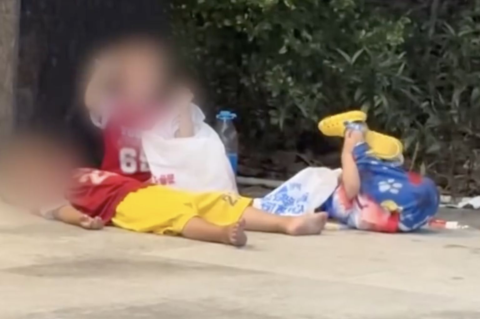 ▲三名幼童在地鐵站口就地躺坐,身邊無大人照看,引起外界關心。(圖/翻攝新京報)