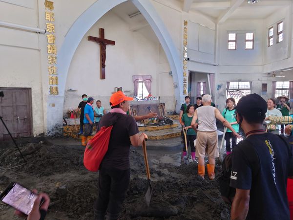 信仰佛教、媽祖的鏟子超人在馬太鞍天主堂救災,似乎在聆聽呂德偉神父指揮。(Threads/@tangho.lin 授權提供)