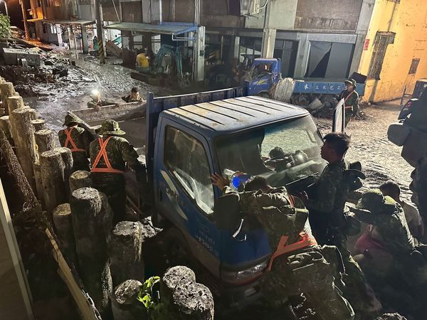 ▲陸軍十軍團官兵合力將陷入淤泥的車輛移走。(圖/十軍團提供)