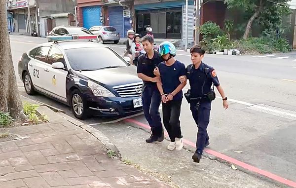 ▲拒檢逃逸的越南籍男子遭警方拘捕後被員警帶回警局偵訊。(圖/龜山警方提供)