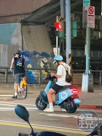 酷被民眾目擊在台北市街頭違規,騎車滑手機。(讀者提供)