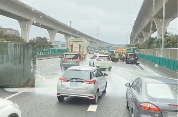 ▲國道桃園北向55.9公里處今天上午發生貨櫃車與休旅車碰撞事故,貨櫃洩漏大量不明液體,後方車輛繞道而行。(圖/記者沈繼昌翻攝)