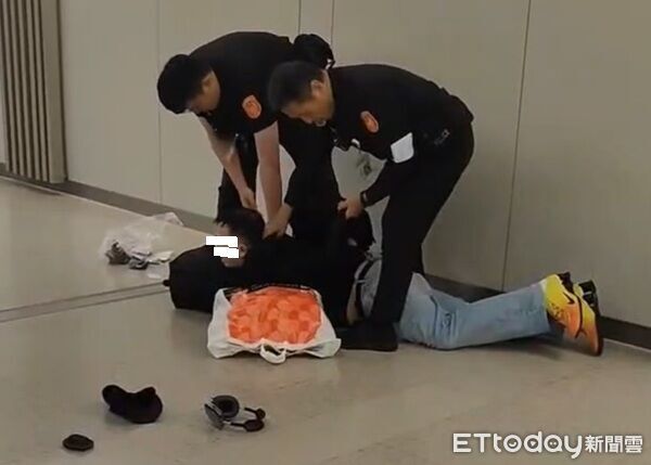 ▲呂姓男酒後在客艙座位抽菸,警方獲報在其下機時予以壓制上銬後逮捕。(圖/翻攝社會事新聞影音)