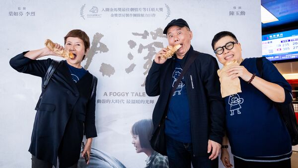 ▲《大濛》導演陳玉勳(中)、監製葉如芬(右)與監製李烈(左)一同吃著電影的象徵物燒餅。(圖/華文創提供)