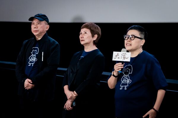 ▲《大濛》導演陳玉勳(中)、監製葉如芬(右)與監製李烈(左)一同吃著電影的象徵物燒餅。(圖/華文創提供)