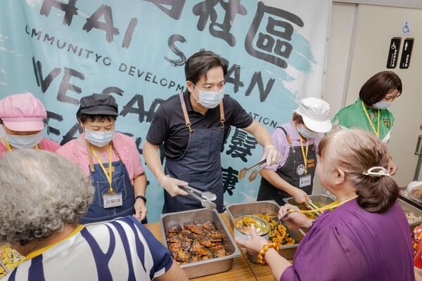 ▲代理市長邱臣遠化身一日志工為長輩盛菜、陪伴共餐。(圖/新竹市政府提供)