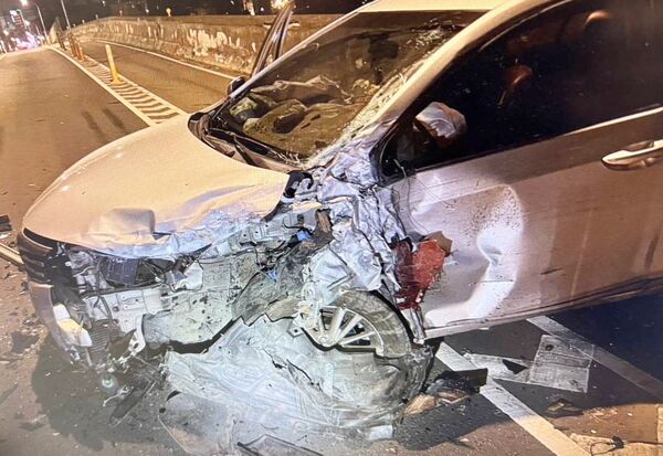 ▲桃園市中豐路陸橋今天凌晨發生2車碰撞事故,遭撞擊白色轎車受損嚴重。(圖/平鎮警方提供)