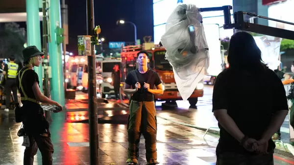 ▲電影《96分鐘》男主角林柏宏(中)於信義區松壽路道路管制與攝影機確認拍攝位置。。(圖/台北市影委會提供)