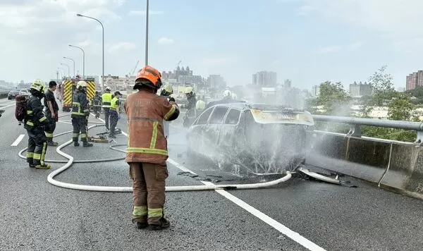 ▲國一五楊高架南向47公里處中午發生火燒車事故,一輛休旅車行駛途中車頭突然冒煙,桃園市消防局派員灌救。(圖/國道一隊提供)