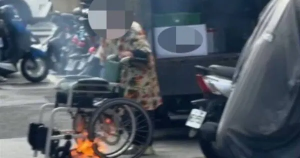 信義區驚見輪椅火光阿嬤路邊放火惹議,路人勸阻反被罵走。(圖 /翻攝畫面)