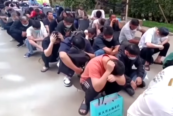 ▲▼KK園區數百名被捕的外籍嫌犯提著行李、整齊坐在道路兩側。(圖/翻攝自YouTube/The Star)