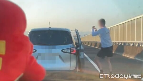 ▲國道離譜畫面曝光,一名外國男子趁塞車時下車站路肩上跳舞。(圖/網友barry07150715授權提供)