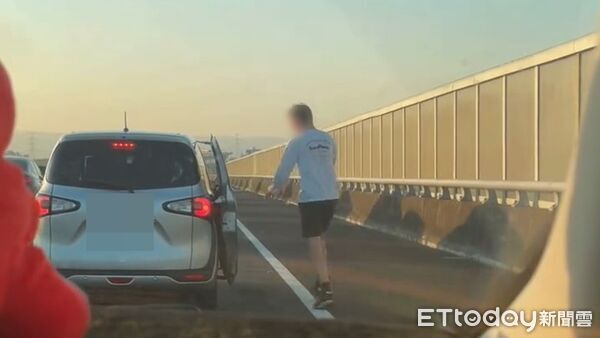 ▲國道離譜畫面曝光,一名外國男子趁塞車時下車站路肩上跳舞。(圖/網友barry07150715授權提供)