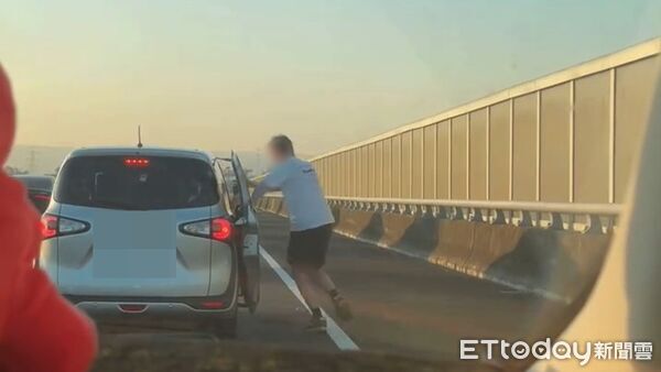▲國道離譜畫面曝光,一名外國男子趁塞車時下車站路肩上跳舞。(圖/網友barry07150715授權提供)