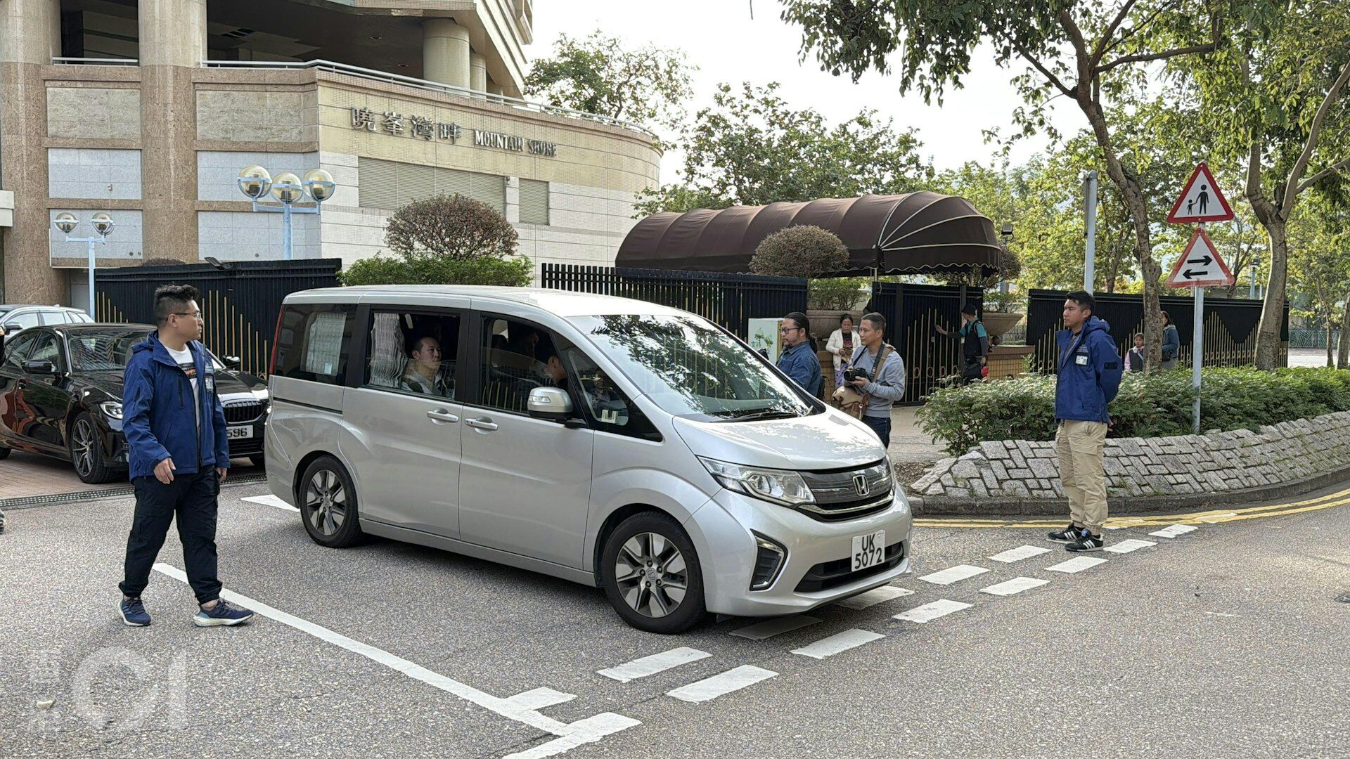 ▲港警押送宏福苑大火涉案人員前往宏業建築公司取證。(圖/香港01)