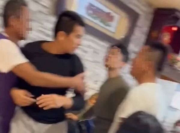 ▲高國豪(右)脫去上衣,揮拳痛毆大哥高聖文頭部,在旁的親戚連忙勸阻。(圖/民眾提供)