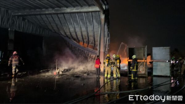 ▲台南市南區明興路工廠倉庫深夜冒出濃煙,消防隊到場後立即布線灌救。(記者林東良翻攝)
