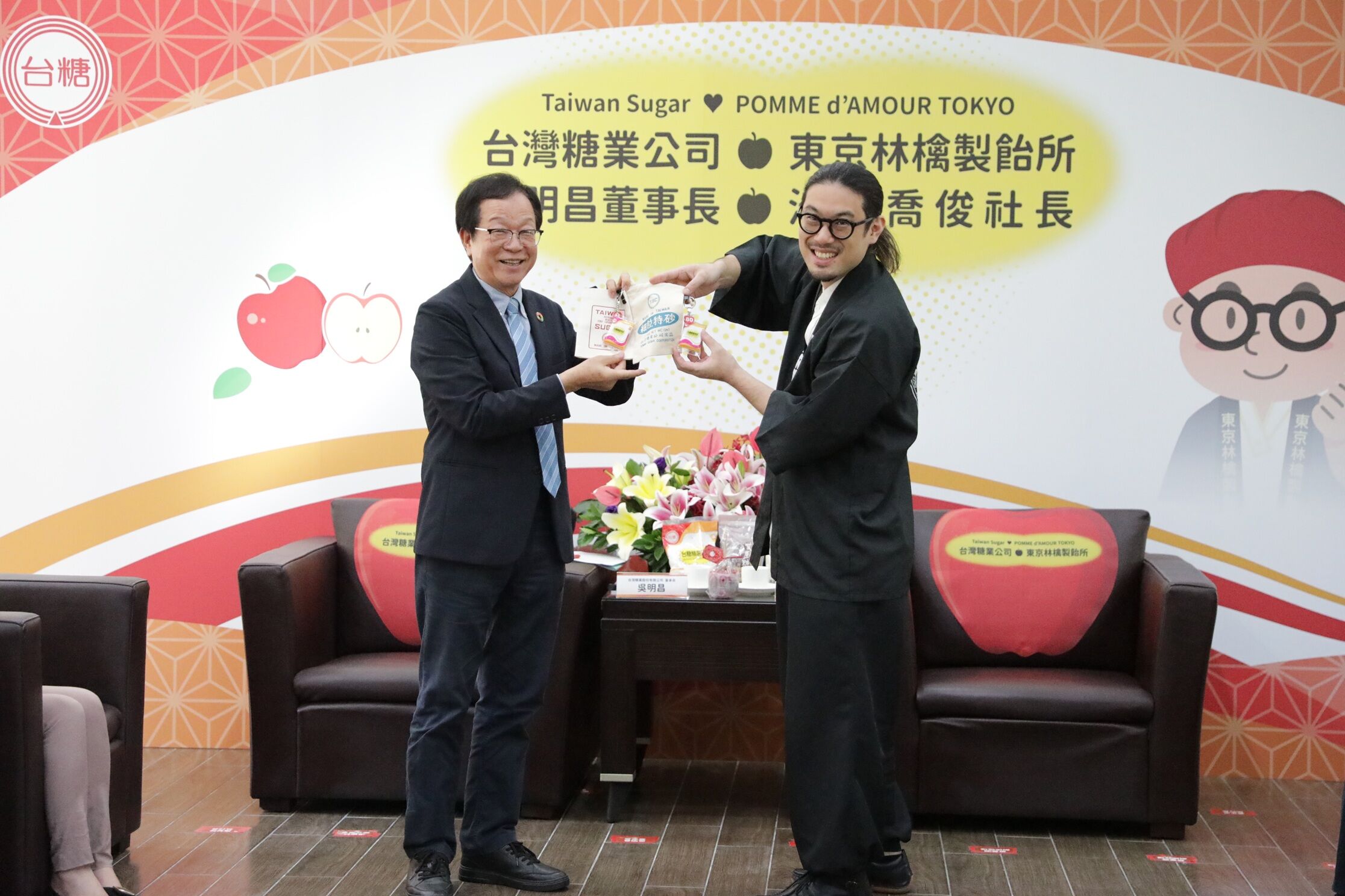 ▲東京林檎製飴所社長池田喬俊(圖右)從台糖董事長吳明昌(圖左)手中得到台糖砂糖造型一卡通。(圖/台糖、池田喬俊X平台提供)