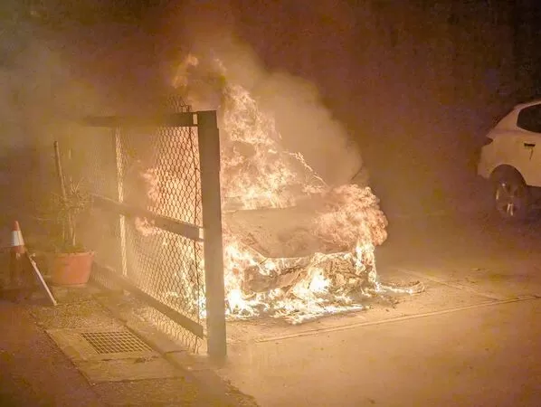 ▲桃園市中壢區西園路上一處停車場,昨晚一輛停放自小客車突然自燃,警消據報後到場灌救。(圖/桃園市消防局提供)