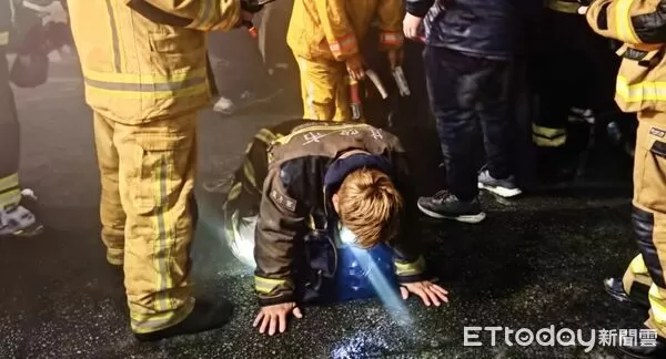 ▲與詹能傑共用共生面罩的義消盧彥宏逃出火場時趴地大口喘氣。(圖/記者郭世賢翻攝)