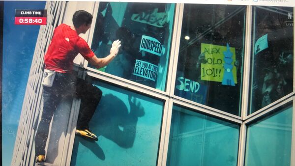 ▲霍諾德路經77樓的Google辦公室時,員工舉標語熱情回應。(圖/翻攝自Netflix)