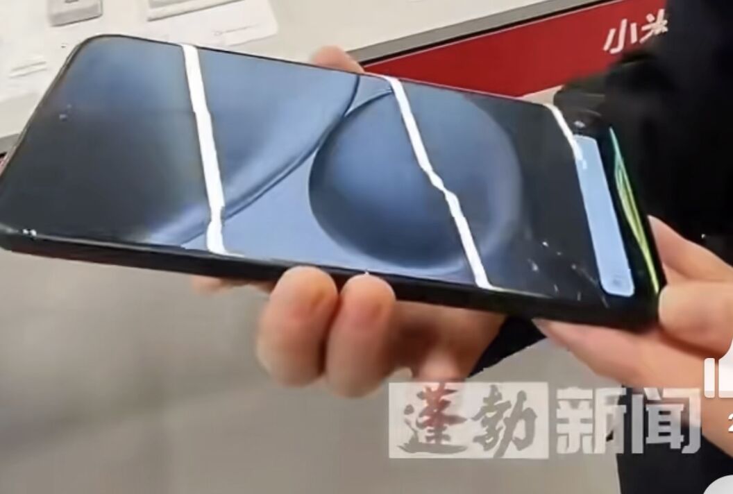 ▲小米店員展示手機防摔功能。(圖/翻攝蓬勃視頻)