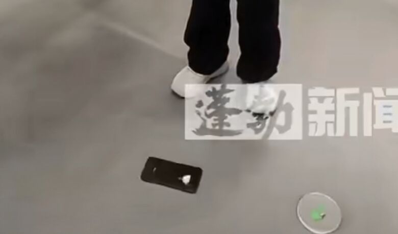 ▲小米店員展示手機防摔功能。(圖/翻攝蓬勃視頻)