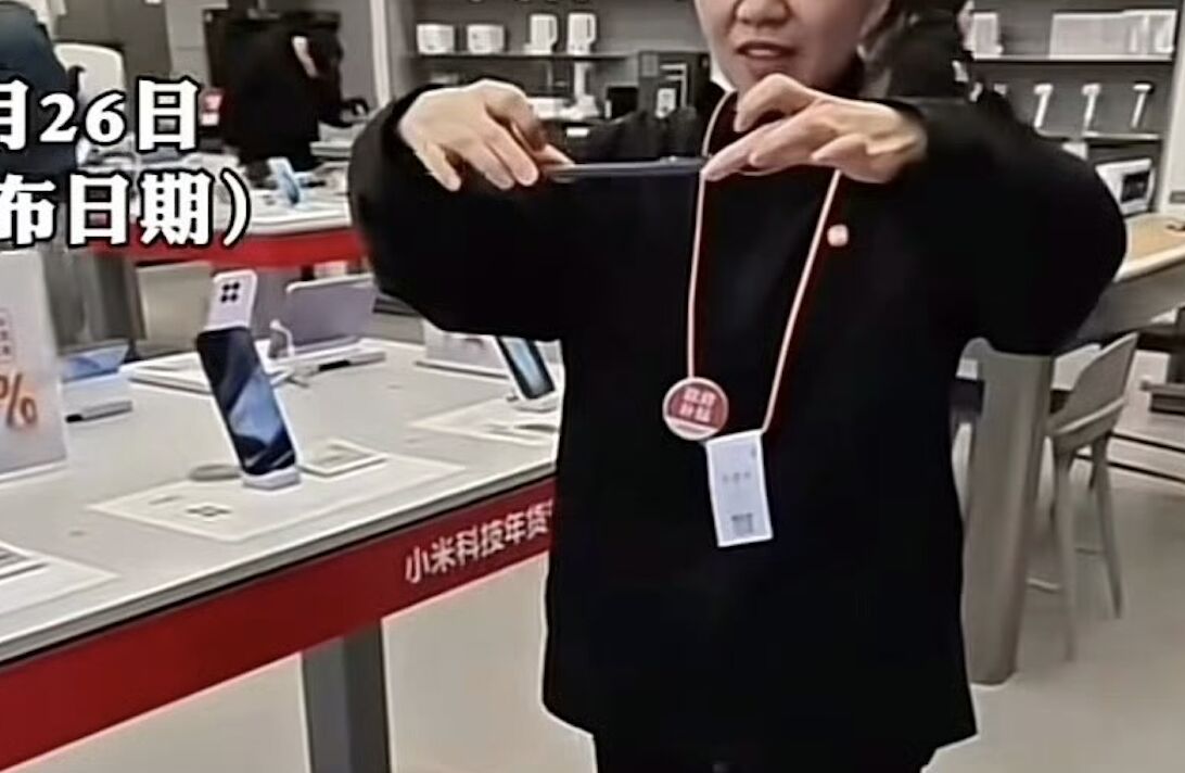 ▲小米店員展示手機防摔功能。(圖/翻攝蓬勃視頻)