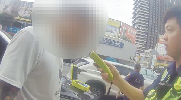 ▲桃園市張姓男子今日上午酒後闖紅燈,連撞2車肇事,警方對張男實施酒測。(圖/桃園警分局提供)