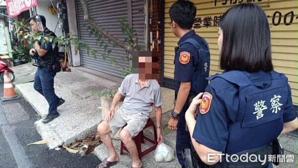 ▲東港警方關心坐在路旁的許姓阿北。(圖/記者陳崑福翻攝)