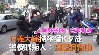 正義大嬸持傘猛K歹徒　警傻眼拖人：這是演習啦