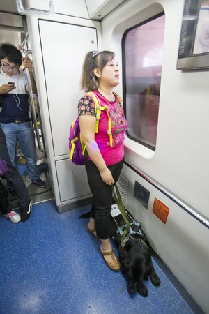 5月1日，陳燕與導盲犬珍妮在指定位置乘坐地鐵。（圖／新華社提供）