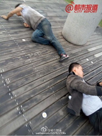 ▼被處罰的員工累癱在地上。（圖／翻攝自都市報導 微博）